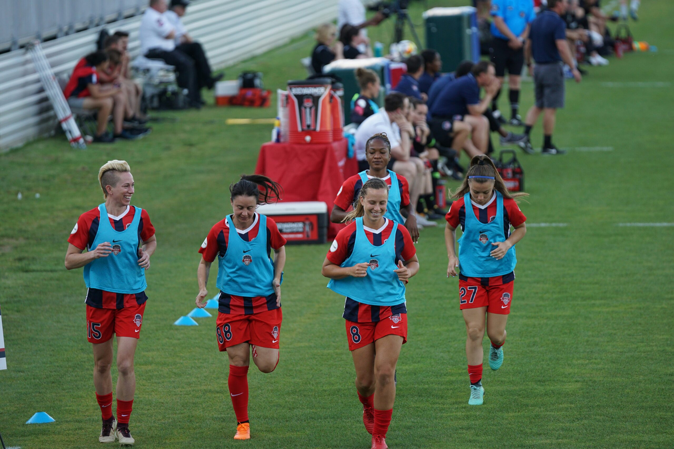 Five female soccer players doing warm ups exercise wearing blue training bibs: Warm-up Exercises and Cool-down Routines