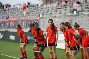 A group of female footballers doing field stretches: Flexibility and Mobility Exercises