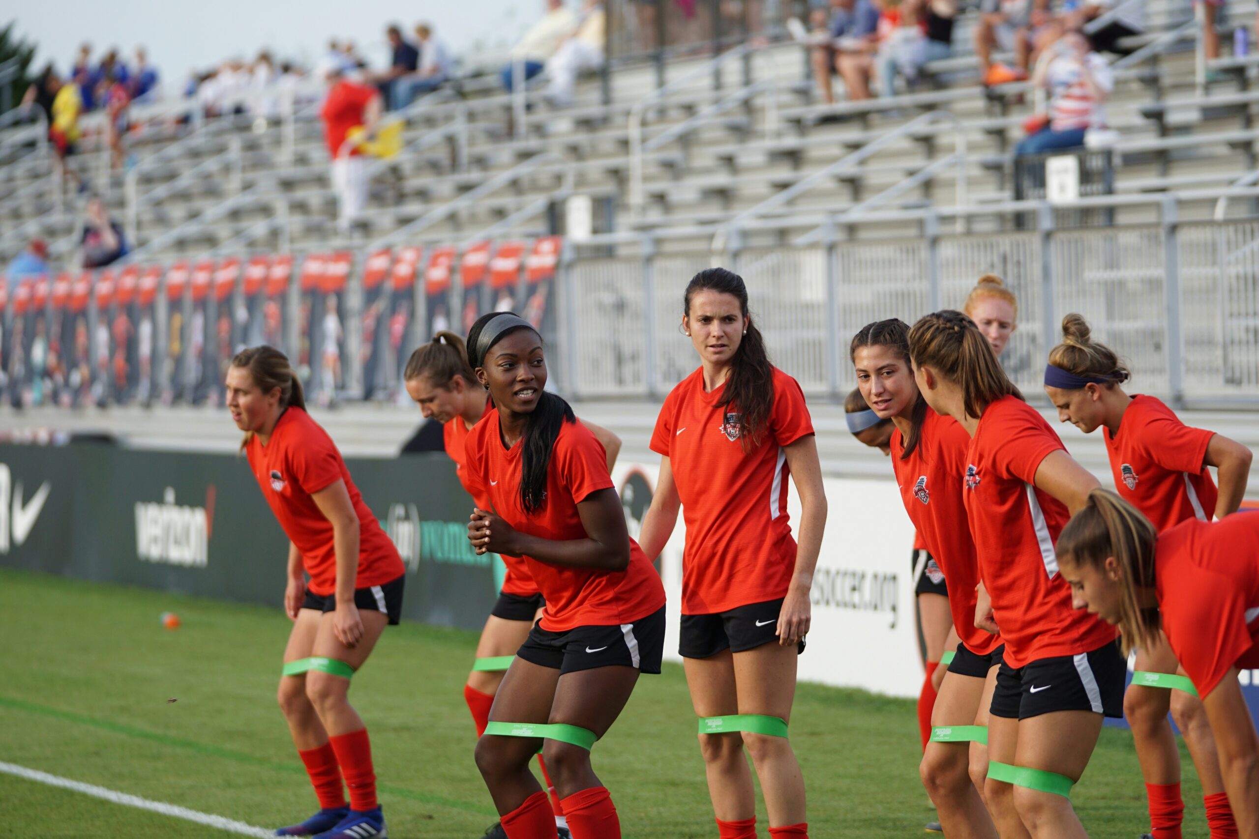 A group of female footballers doing field stretches: Flexibility and Mobility Exercises