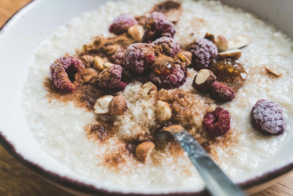 A bowl of oatmeal topped with nuts and raspberries for breakfast: best breakfast choices