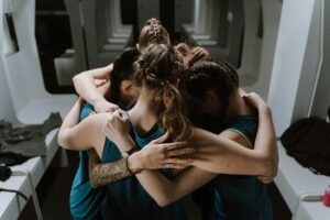 A group of sports women in group huddle with different hairstyles: Hairstyles for Female Soccer Players