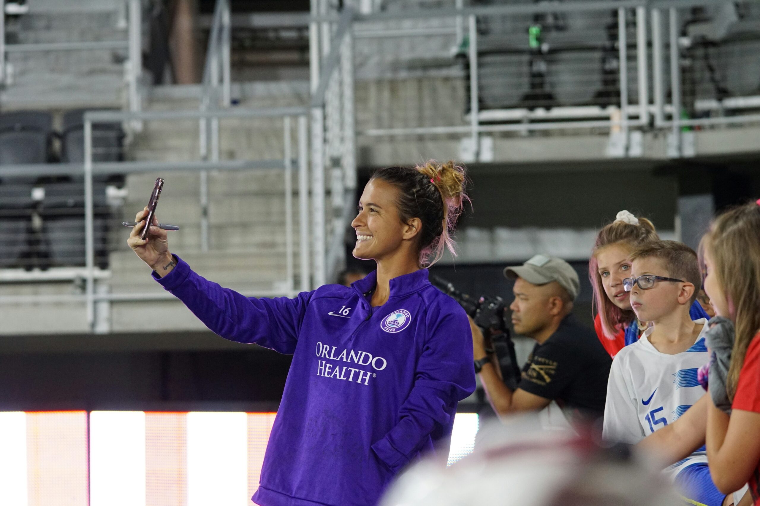 A female soccer player taking a selfie with football fans: avoid social media overload