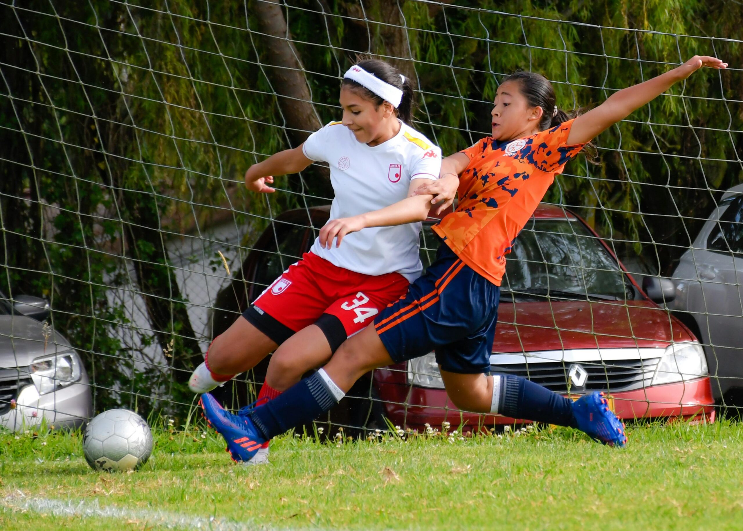 a female footballer doing a clean tackle to her opponent