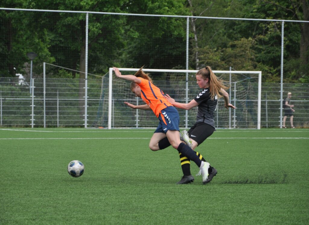 two women playing football on a field: women's football