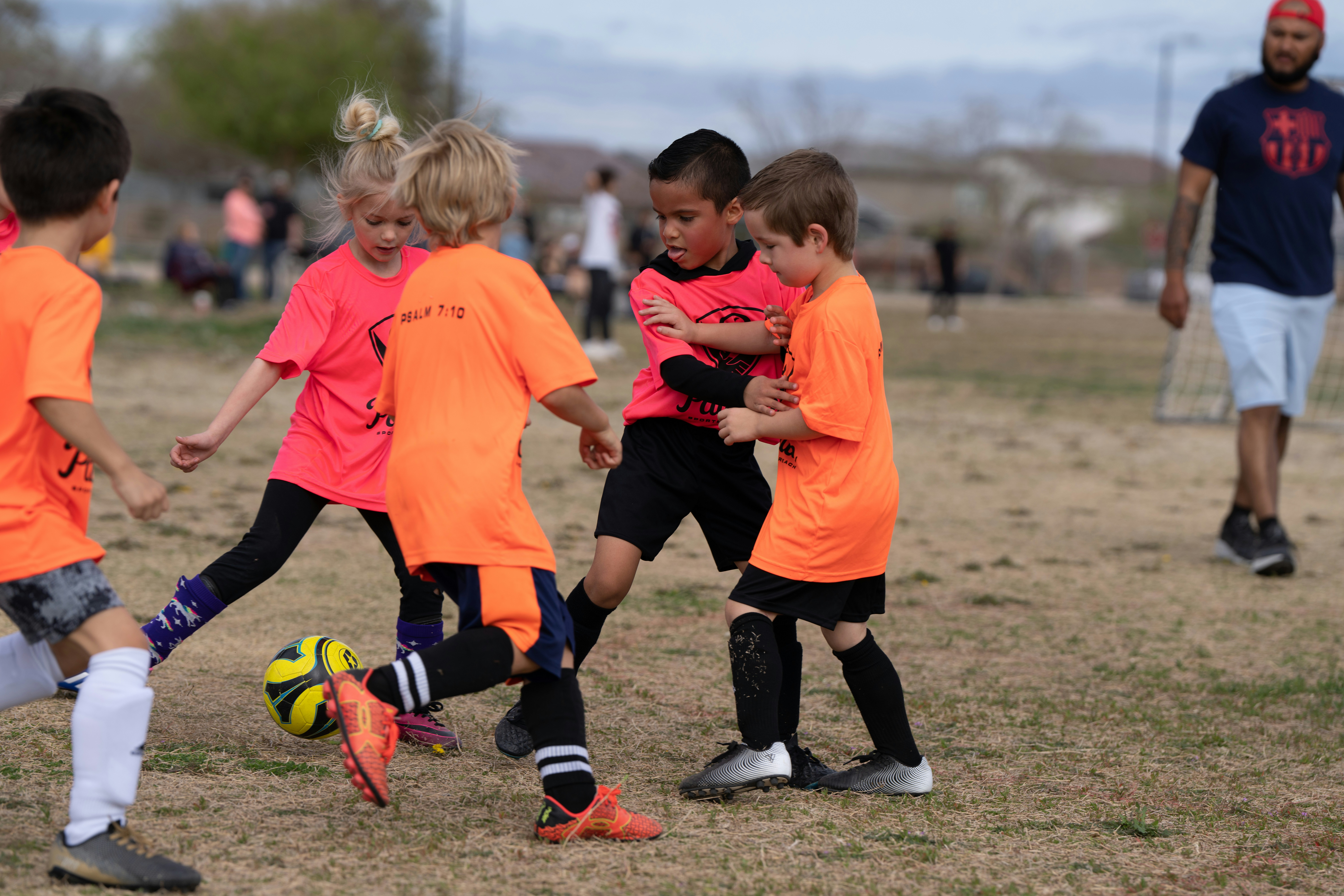 A group of young boys alongside young soccer girls playing a game of soccer: Rewarding Parts of Learning Soccer