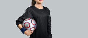 A female holding a soccer ball on her right: Women's Football Career Guide