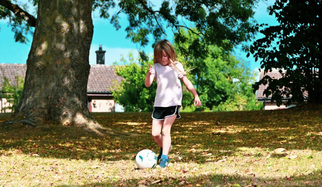 A soccer girl kick a soccer ball outside during daytime: how to become a pro female soccer player