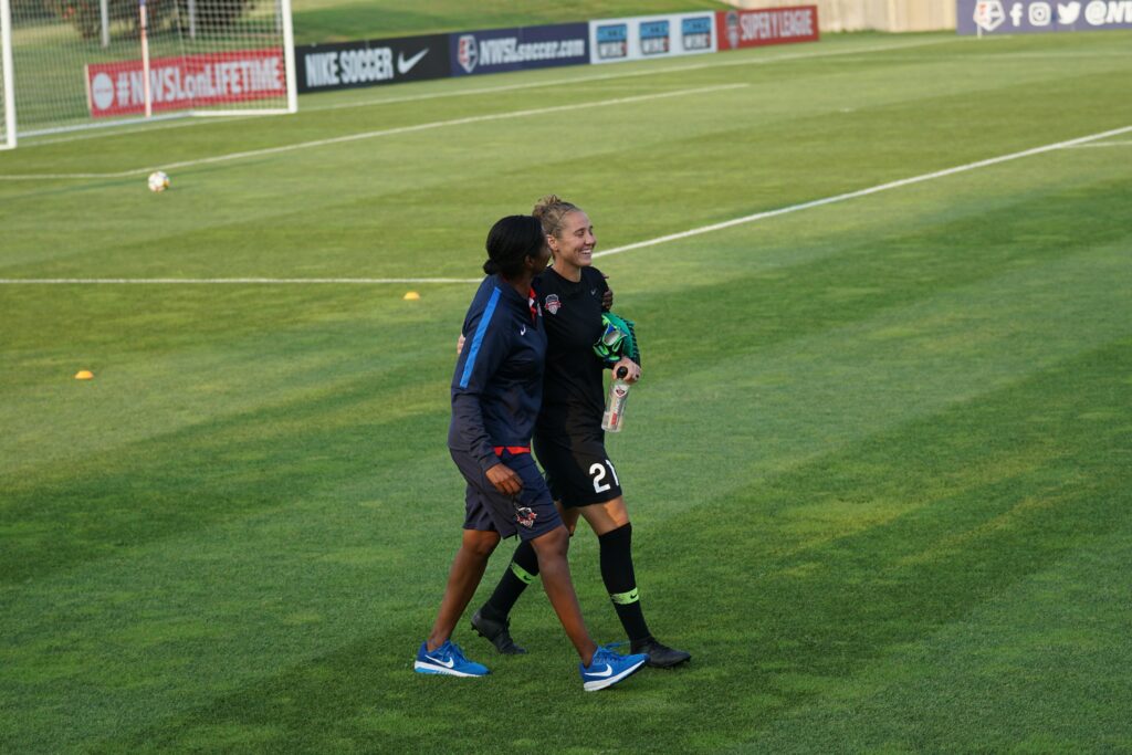 two soccer career women walking side by side on a soccer field during daytime: Women's football career guide