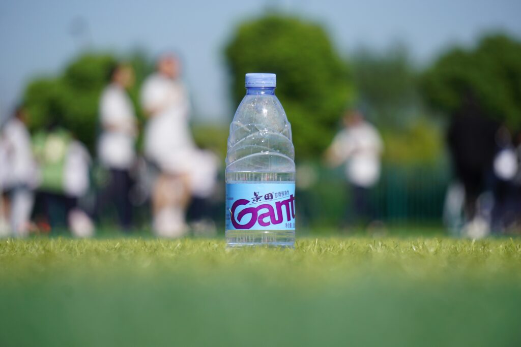 A bottle of water on a grassy field: what to drink after a match