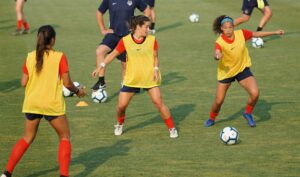 A group of girls playing soccer at daytime first football trial