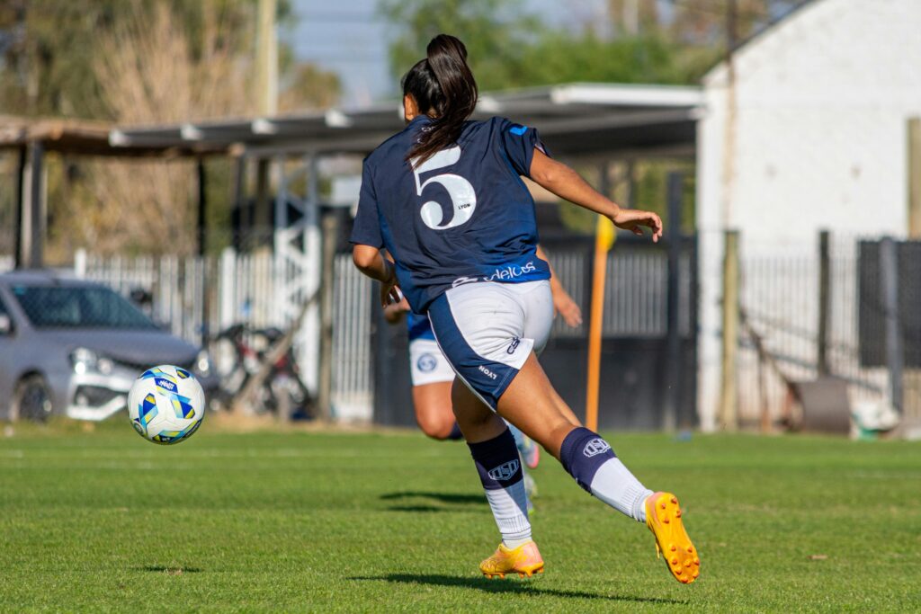 female soccer player kicking ball